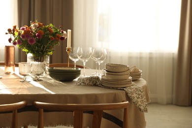 Photo of Stylish table setting with dishware, glasses and beautiful flowers indoors