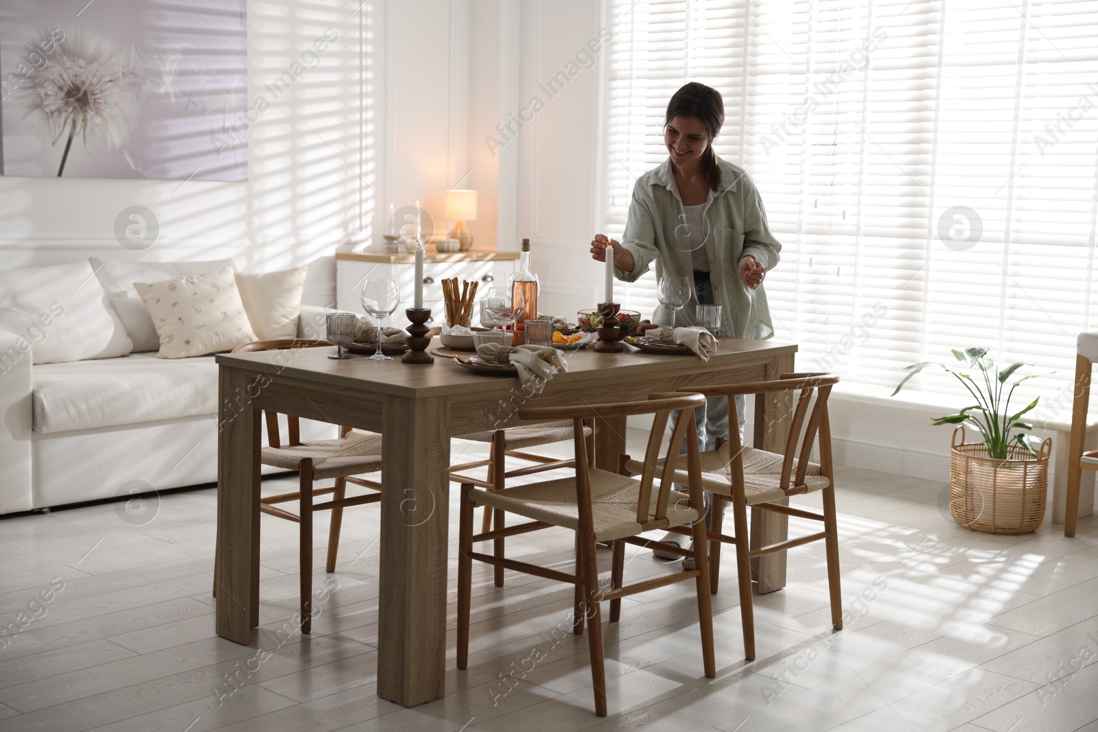 Photo of Woman setting table for dinner at home