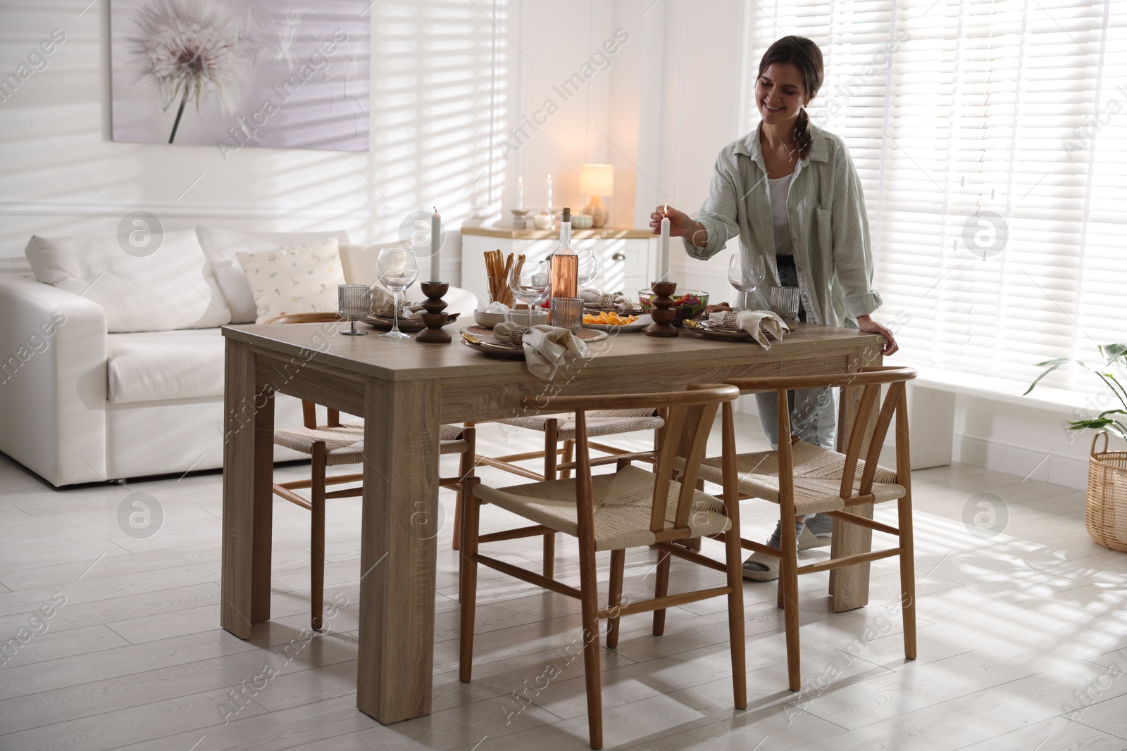 Photo of Woman setting table for dinner at home