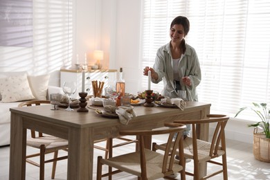 Photo of Woman setting table for dinner at home