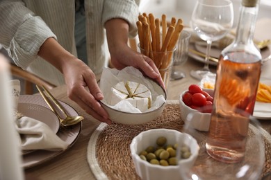 Photo of Woman setting table for dinner at home, closeup