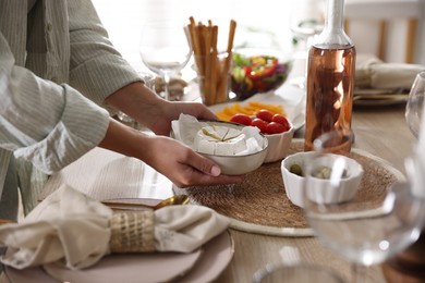 Photo of Woman setting table for dinner at home, closeup