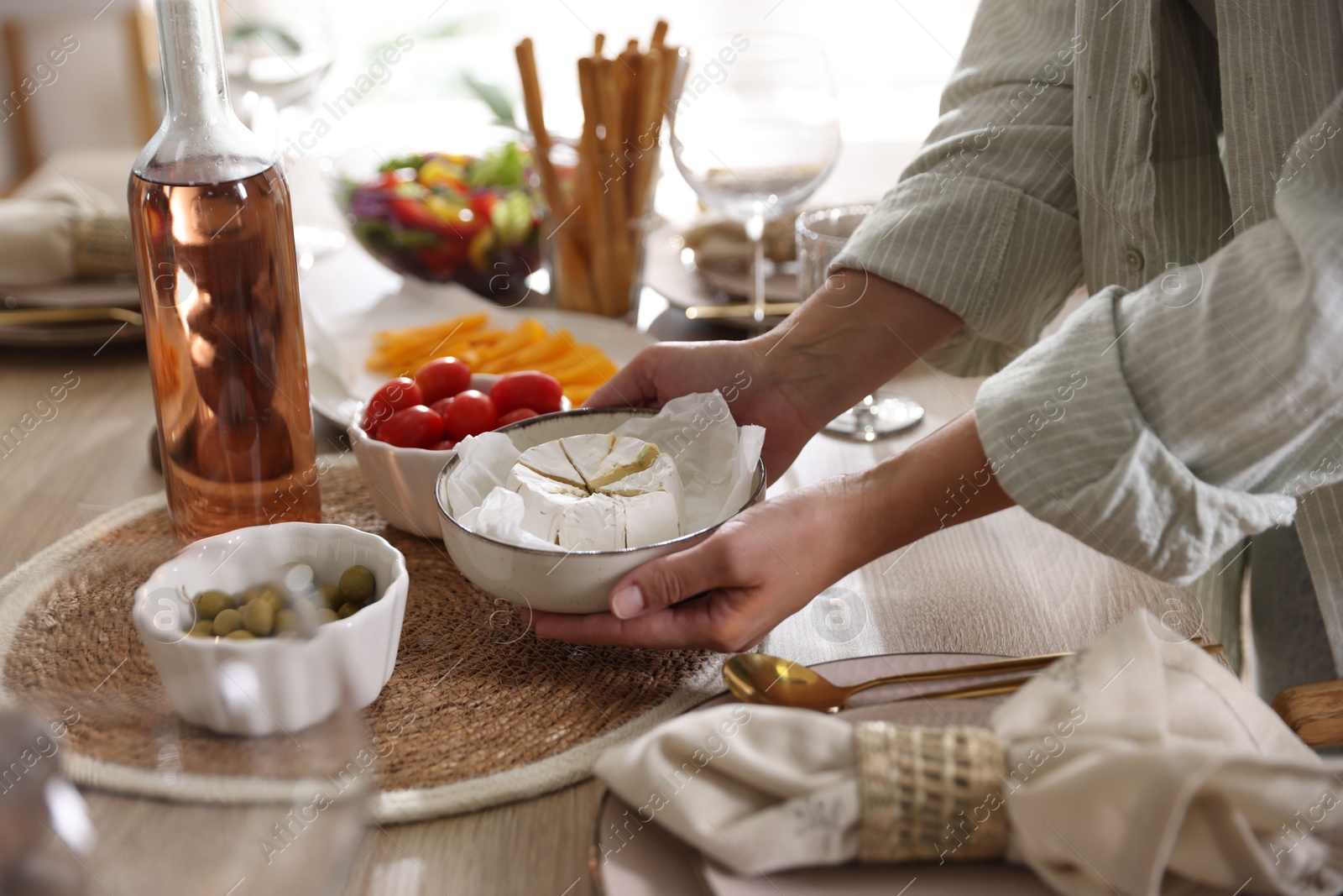 Photo of Woman setting table for dinner at home, closeup