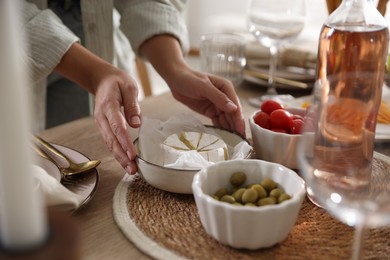 Photo of Woman setting table for dinner at home, closeup