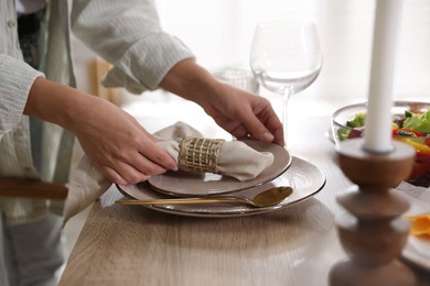 Photo of Woman setting table for dinner at home, closeup