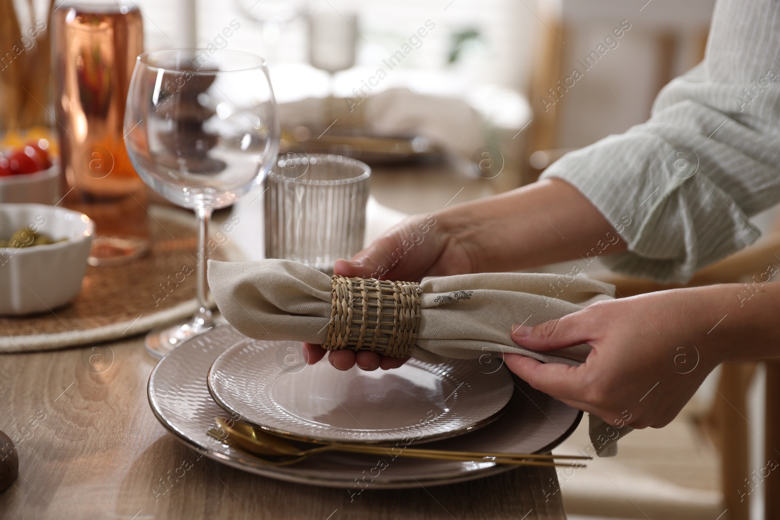 Photo of Woman setting table for dinner at home, closeup