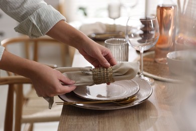 Photo of Woman setting table for dinner at home, closeup