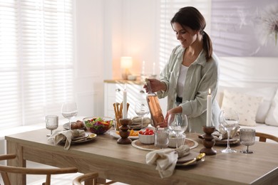 Photo of Woman setting table for dinner at home