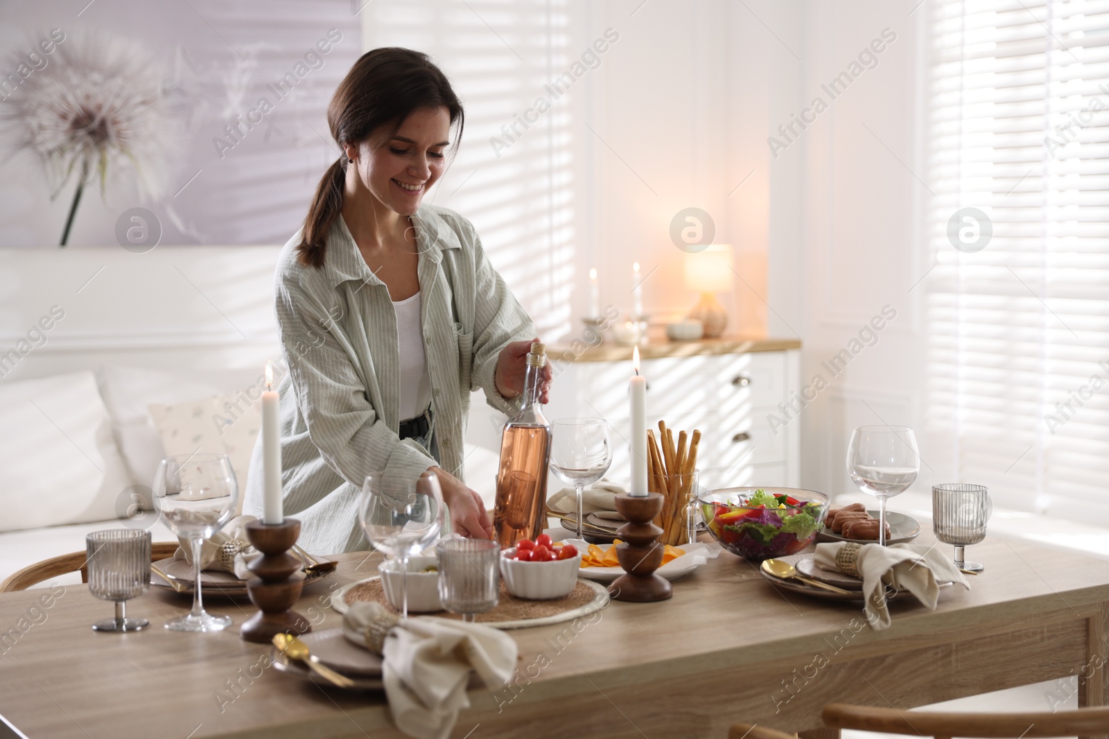 Photo of Woman setting table for dinner at home