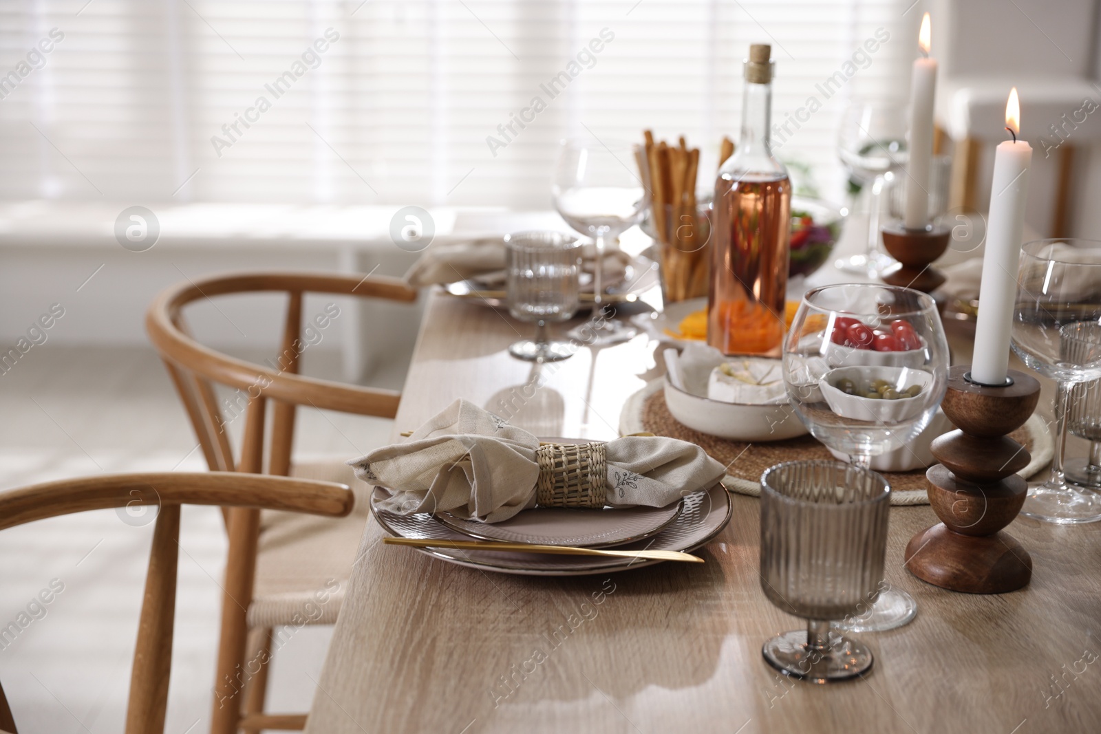 Photo of Stylish table setting with dishware, cutlery and burning candles indoors