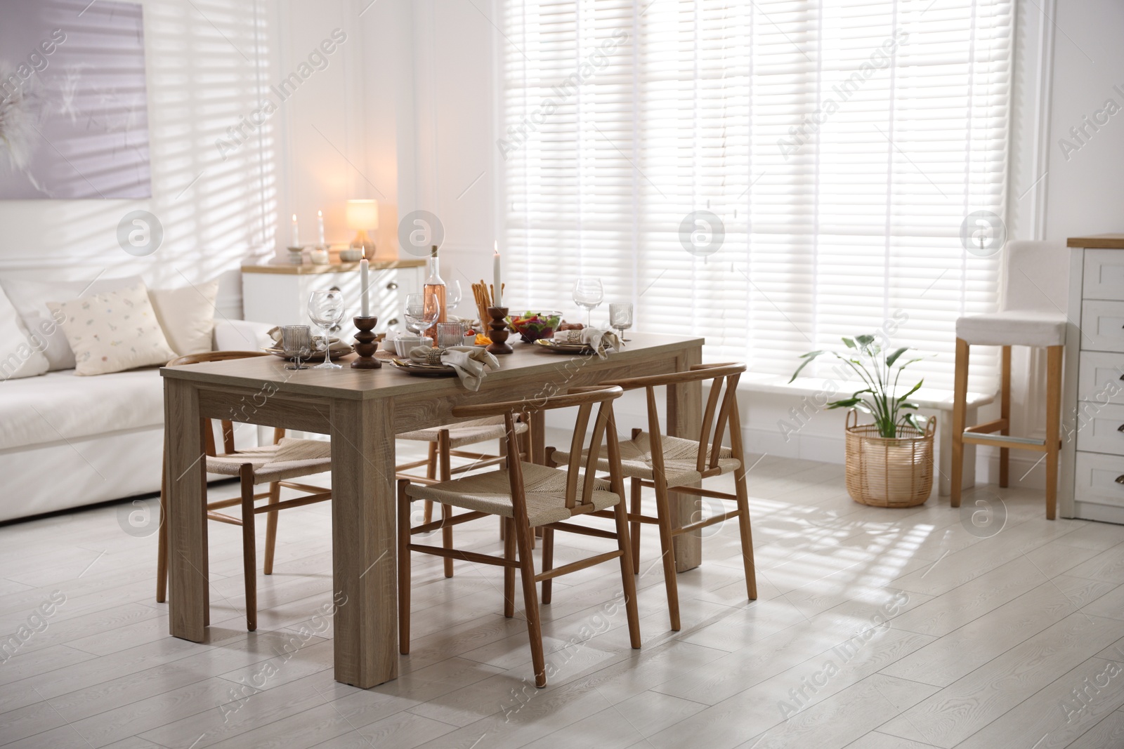 Photo of Stylish table setting with dishware, cutlery and burning candles indoors