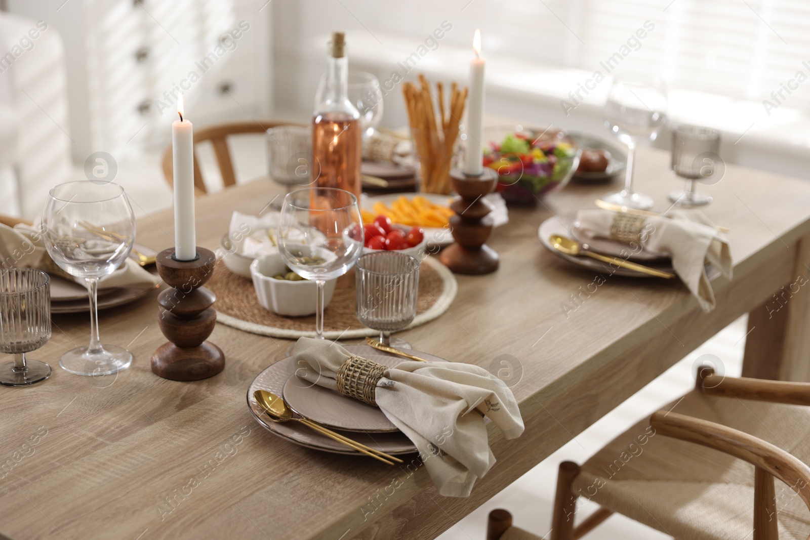 Photo of Stylish table setting with dishware, cutlery and burning candles indoors