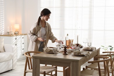 Photo of Woman setting table for dinner at home