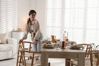 Photo of Woman setting table for dinner at home