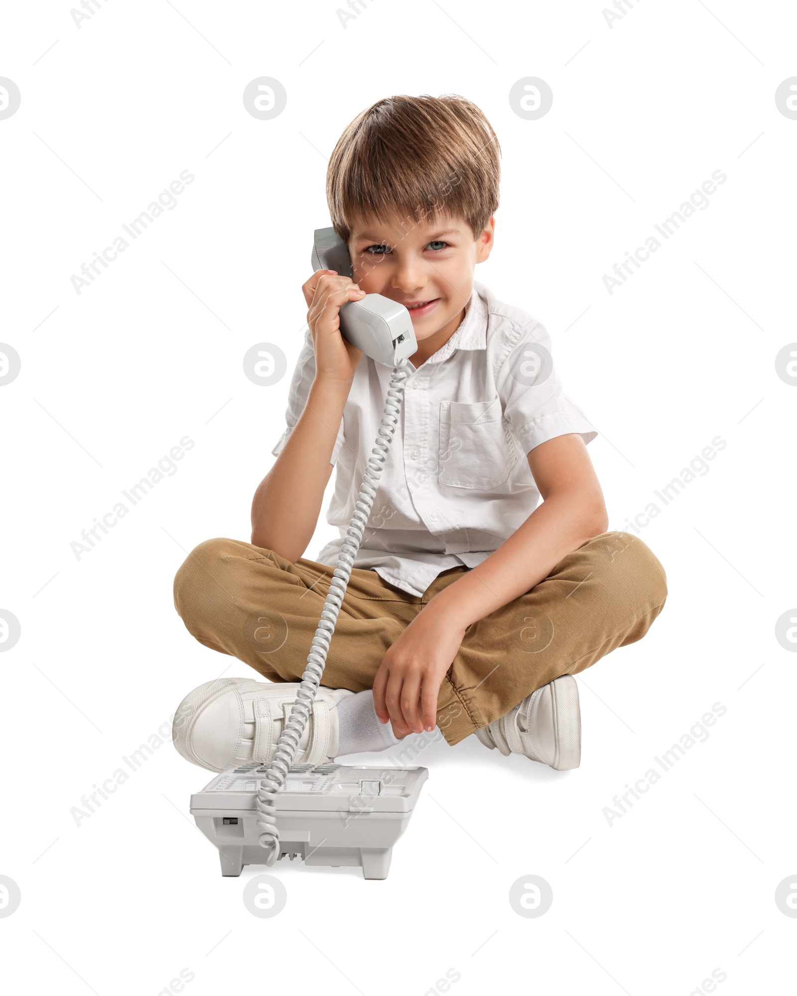 Photo of Cute little boy with telephone on white background