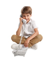 Photo of Cute little boy with telephone on white background