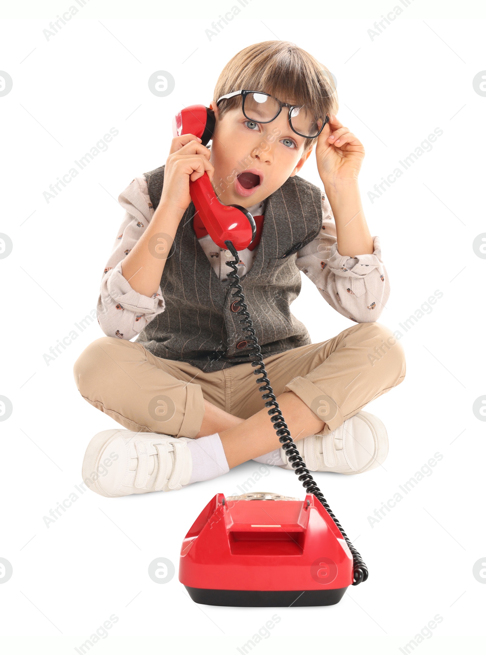 Photo of Cute little boy with old telephone on white background