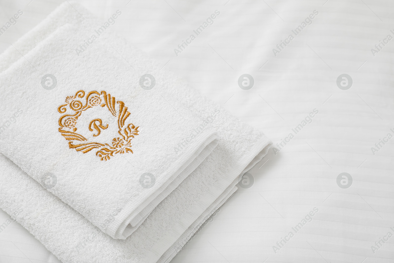 Photo of Stack of towels on clean linens indoors, closeup