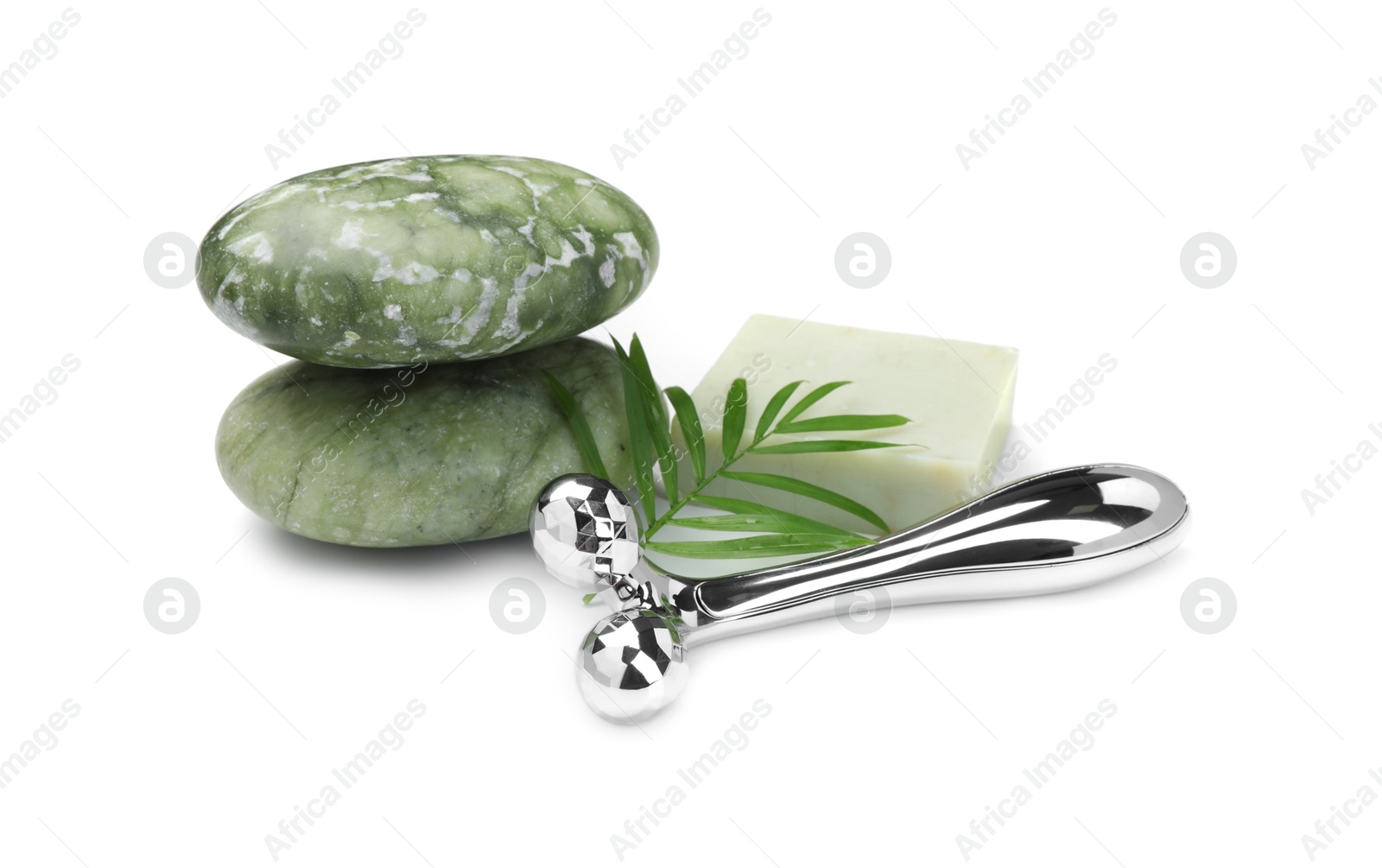 Photo of Face roller, stones and soap isolated on white