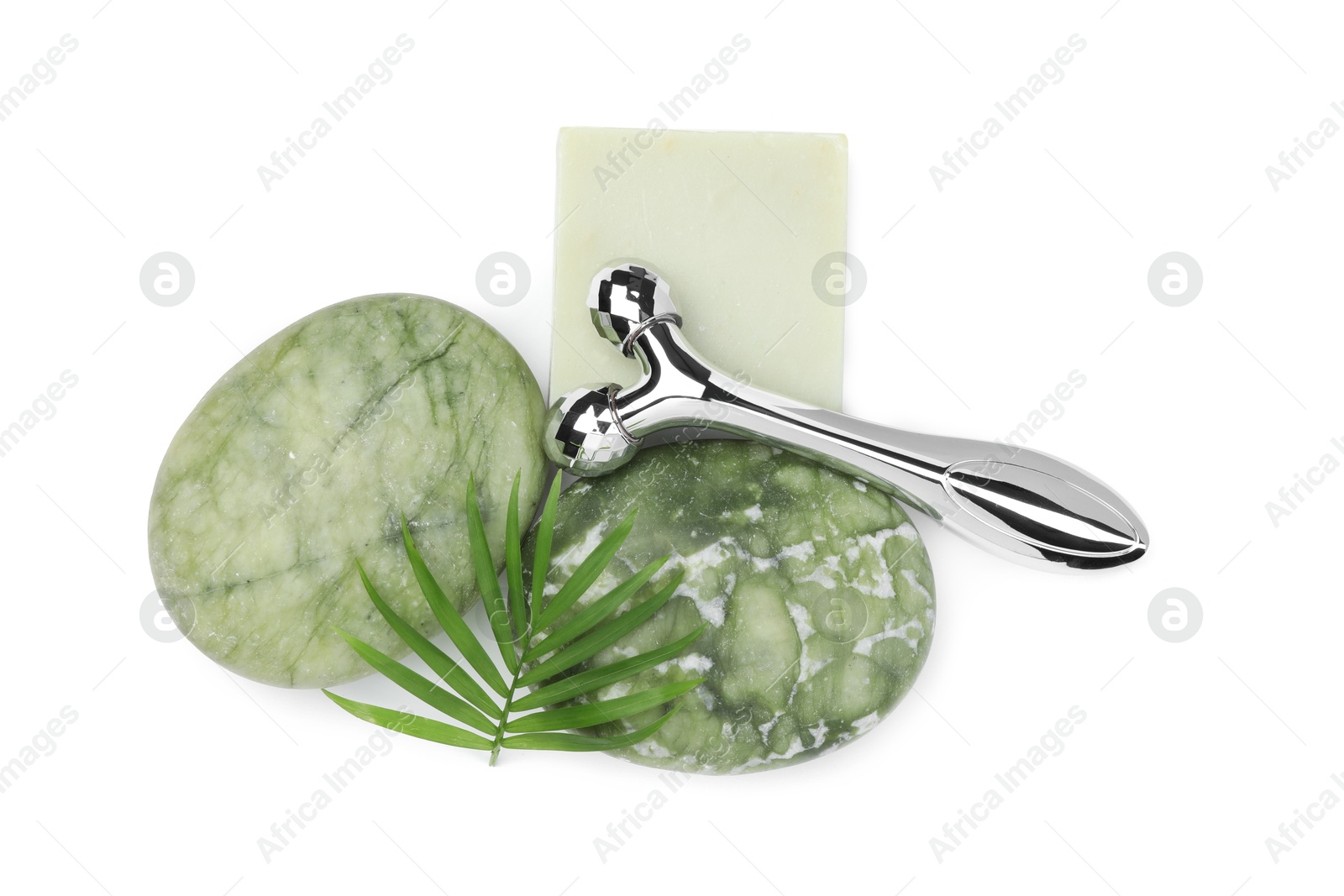 Photo of Face roller, stones and soap isolated on white, top view