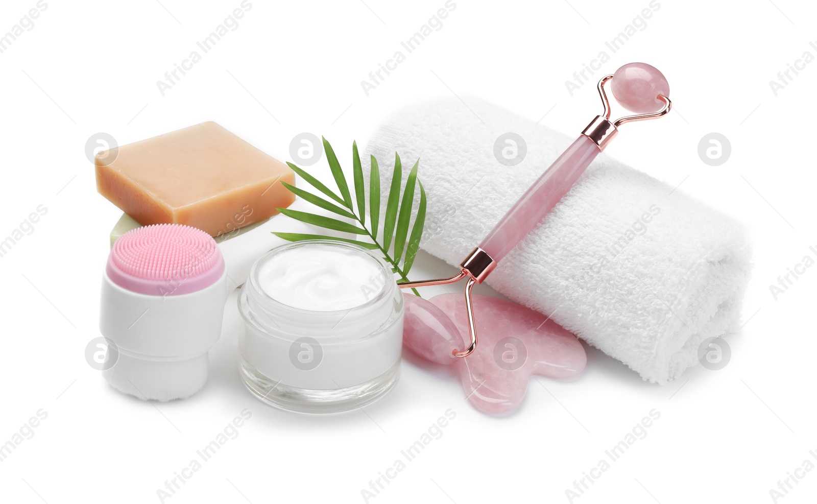 Photo of Face roller, cosmetic products, towel and gua sha isolated on white