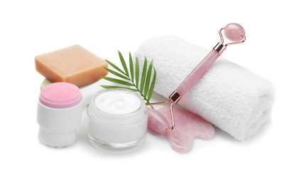 Face roller, cosmetic products, towel and gua sha isolated on white