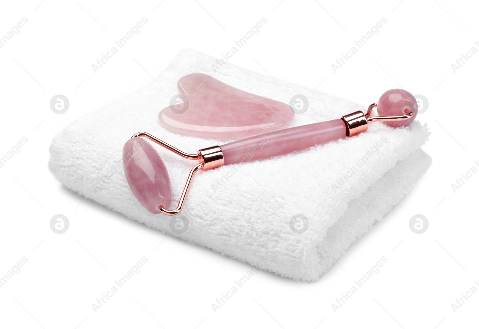 Photo of Face roller, gua sha tool and towel isolated on white