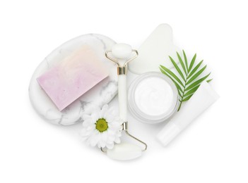 Face roller, cosmetic products, soap, gua sha and flower isolated on white, top view