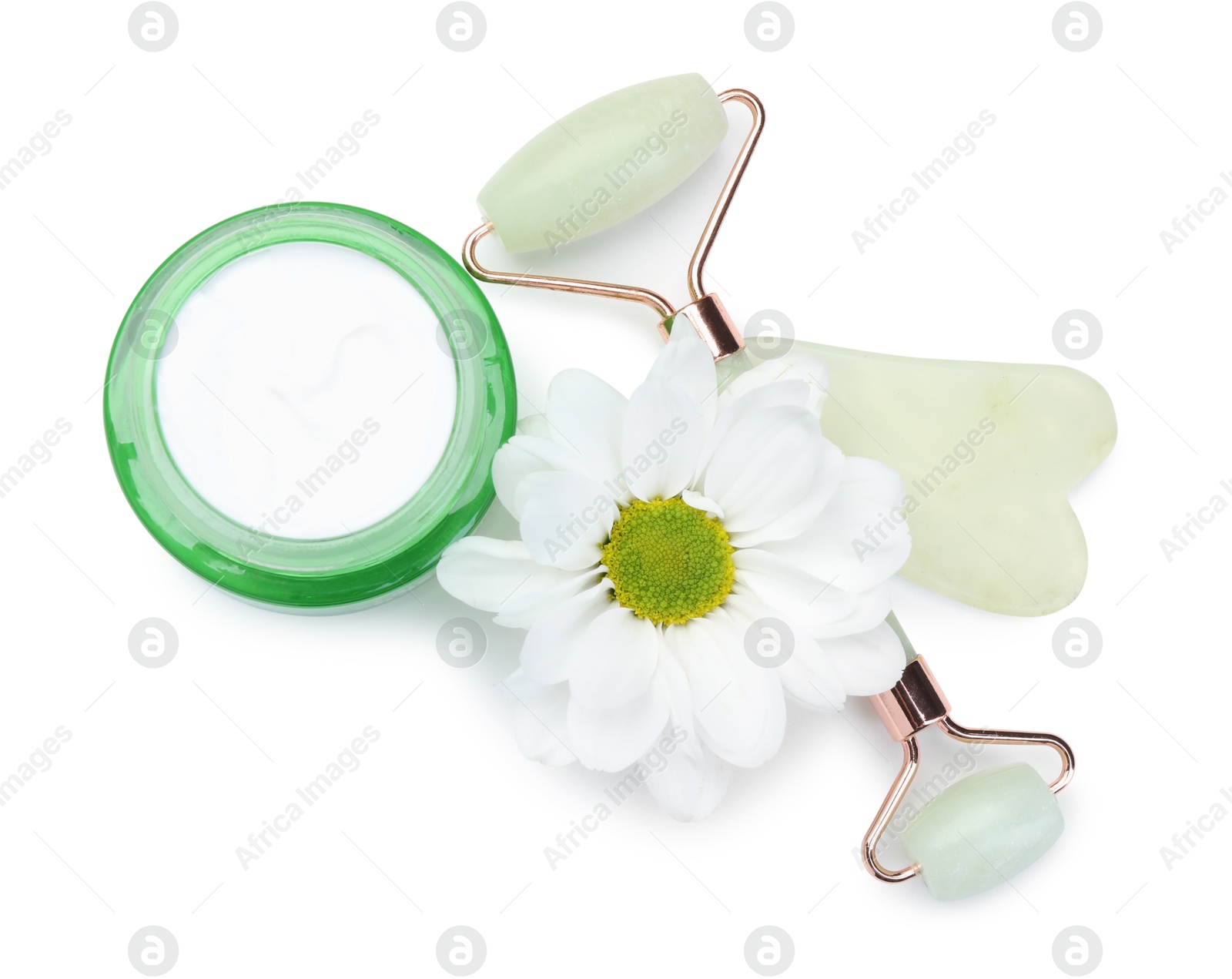 Photo of Face roller, cream, gua sha and flower isolated on white, top view