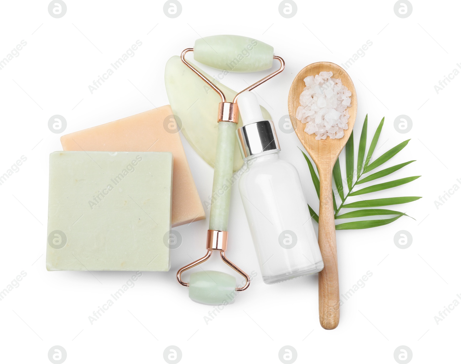 Photo of Face roller, soap bars and sea salt isolated on white, top view