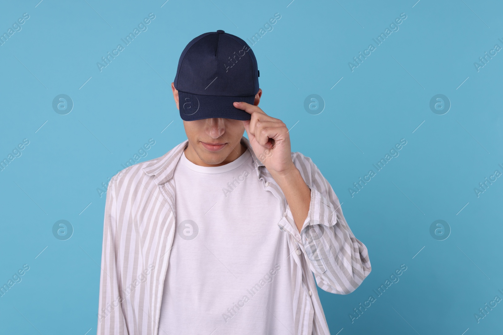 Photo of Man in stylish baseball cap on light blue background. Mockup for design