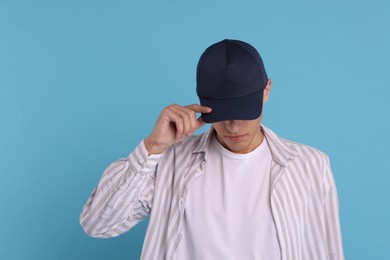 Photo of Man in stylish baseball cap on light blue background. Mockup for design