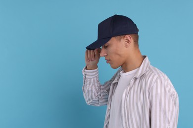 Photo of Man in stylish baseball cap on light blue background. Mockup for design