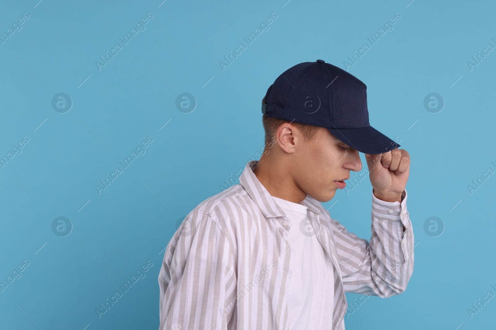 Photo of Man in stylish baseball cap on light blue background. Mockup for design