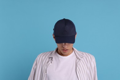 Photo of Man in stylish baseball cap on light blue background. Mockup for design