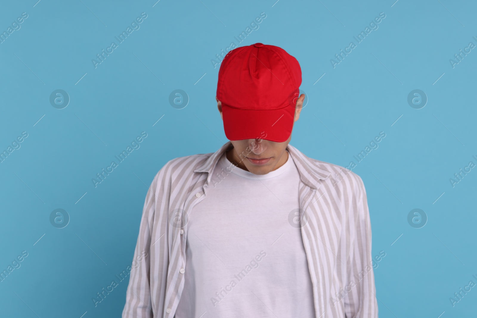 Photo of Man in stylish baseball cap on light blue background. Mockup for design