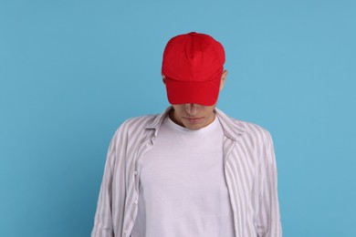 Photo of Man in stylish baseball cap on light blue background. Mockup for design