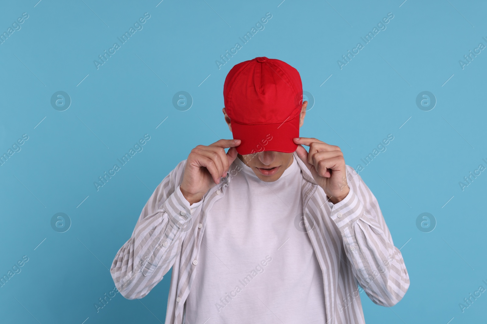 Photo of Man in stylish baseball cap on light blue background. Mockup for design