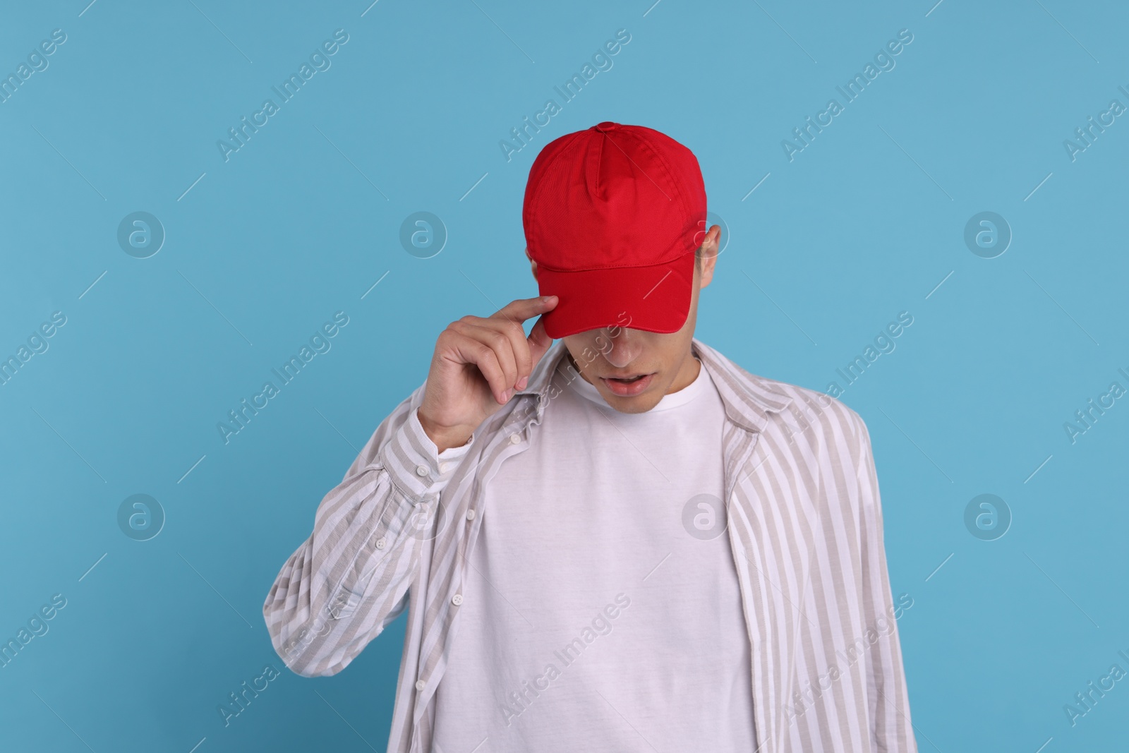 Photo of Man in stylish baseball cap on light blue background. Mockup for design