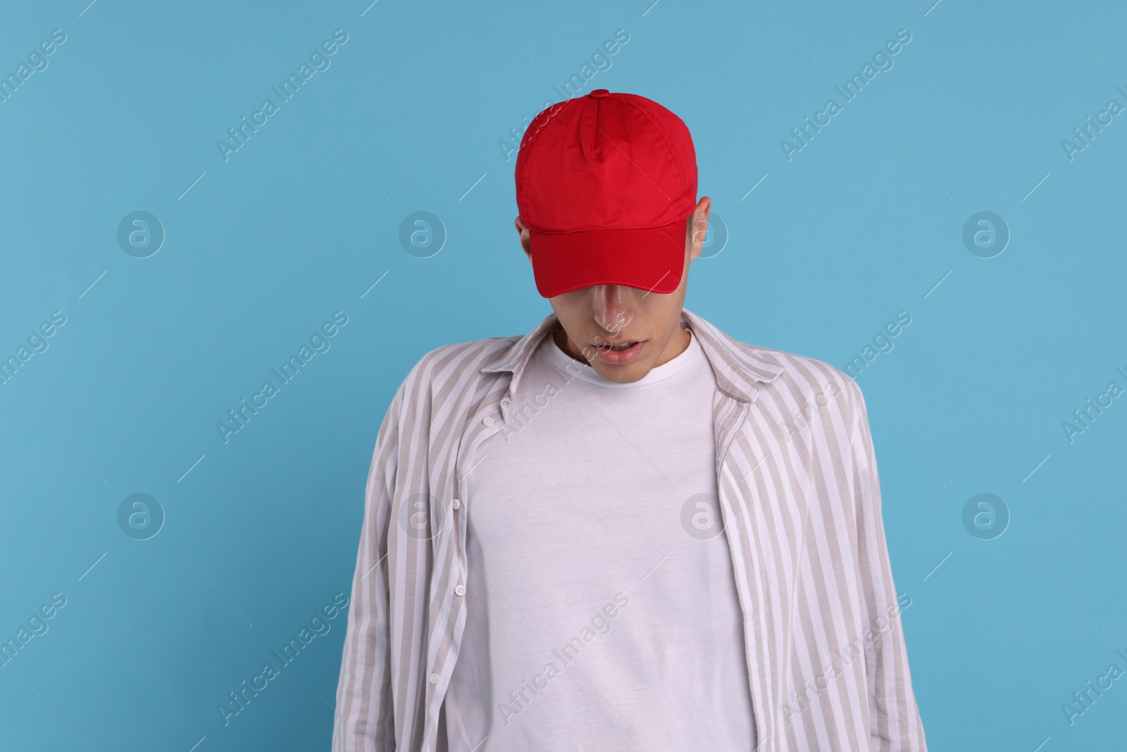 Photo of Man in stylish baseball cap on light blue background. Mockup for design