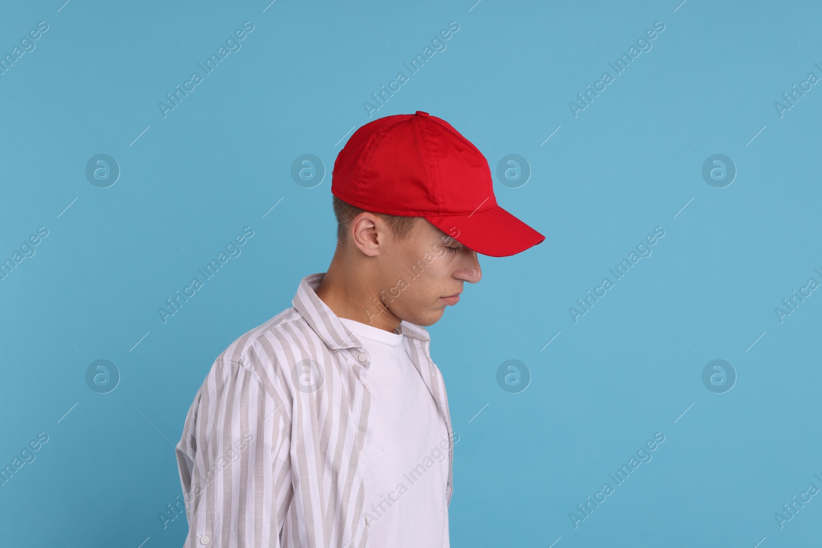 Photo of Man in stylish baseball cap on light blue background. Mockup for design