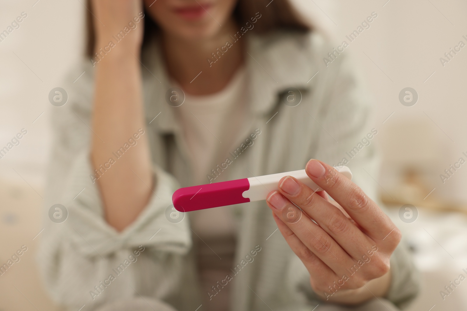 Photo of Woman with negative pregnancy test at home, closeup