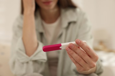 Photo of Woman with negative pregnancy test at home, closeup