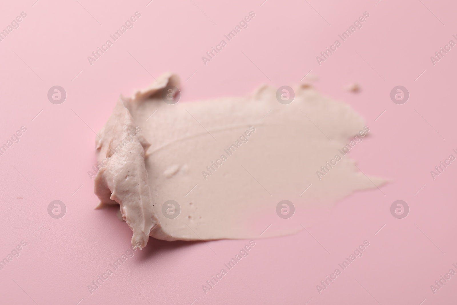 Photo of Cream on pink background, top view. Sample of cosmetic product