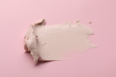 Photo of Cream on pink background, top view. Sample of cosmetic product