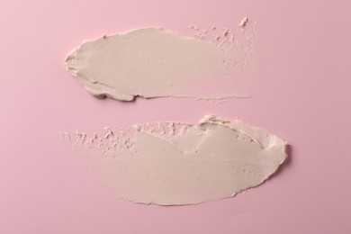 Photo of Cream on pink background, top view. Samples of cosmetic product