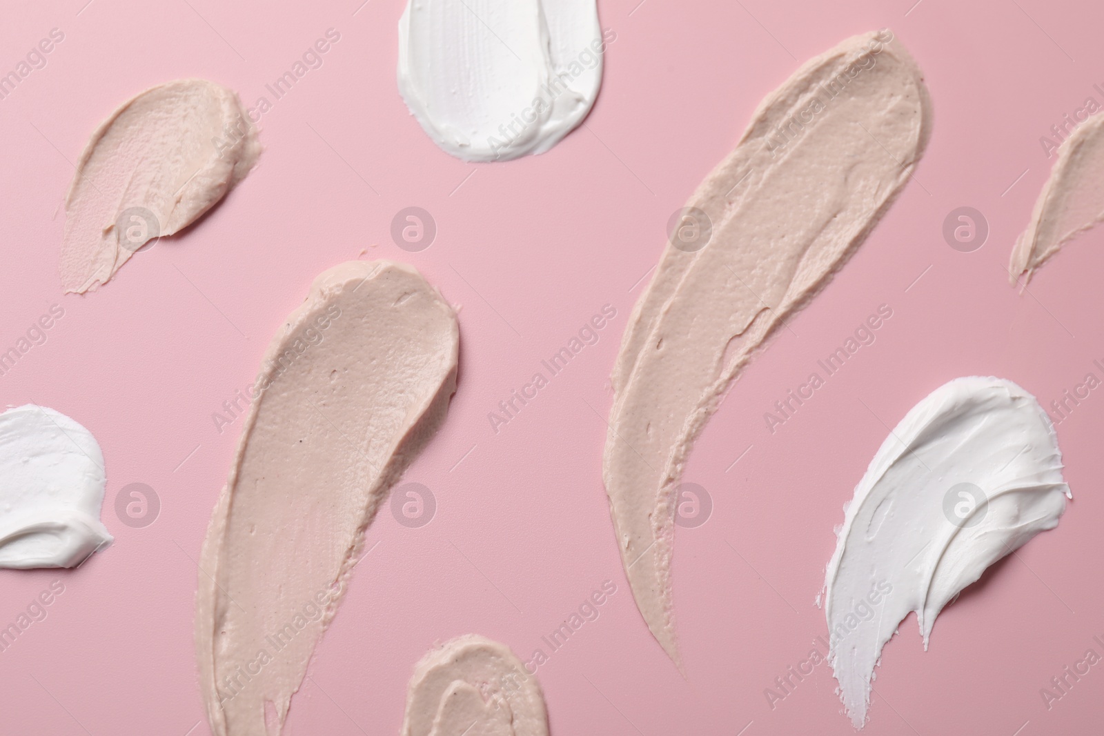 Photo of Cream on pink background, flat lay. Samples of cosmetic product