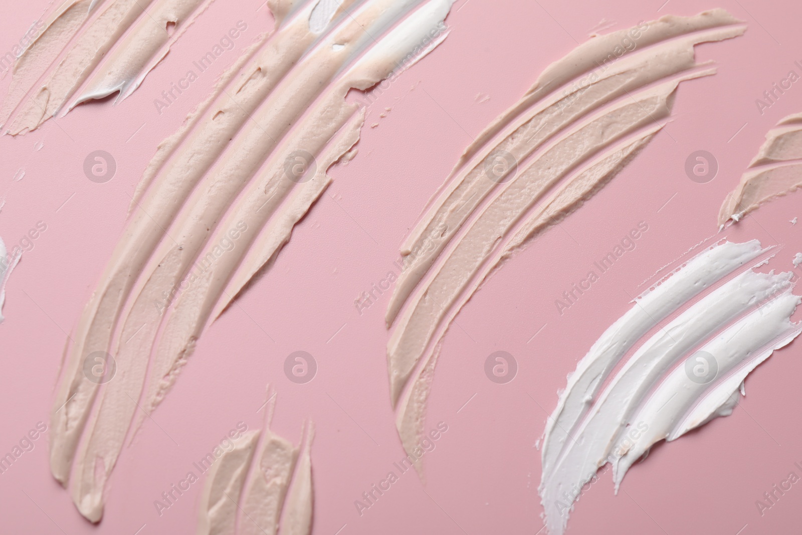 Photo of Cream on pink background, flat lay. Samples of cosmetic product