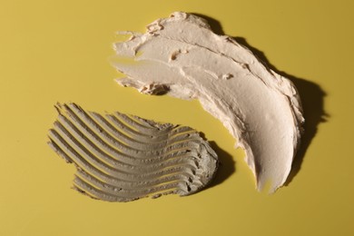 Samples of cosmetic products on yellow background, top view