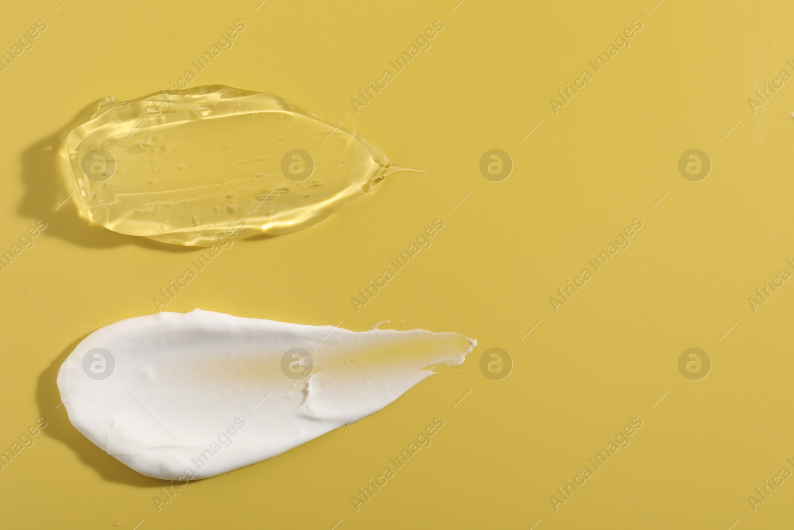 Photo of Samples of different cosmetic products on yellow background, top view. Space for text